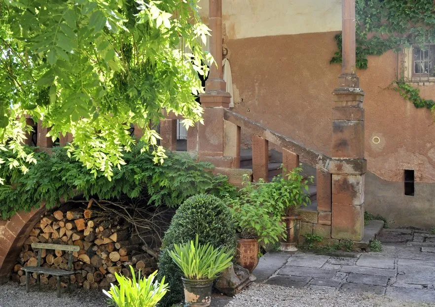 Escalier sous porche et le bois qui vous attend pour une bonne flambée